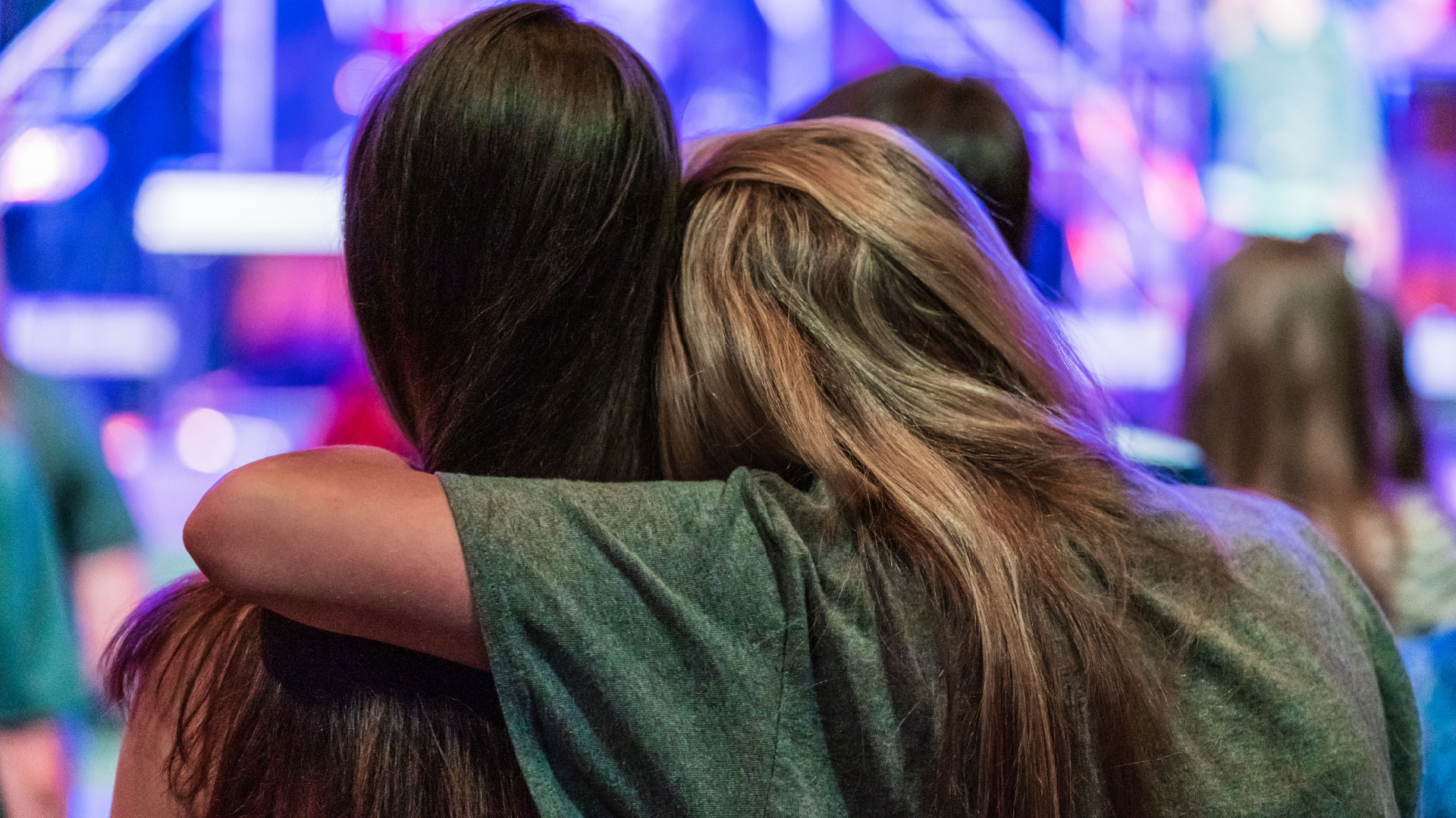 Two 7th grade friends hugging during an Axis meeting at Brookwood Church